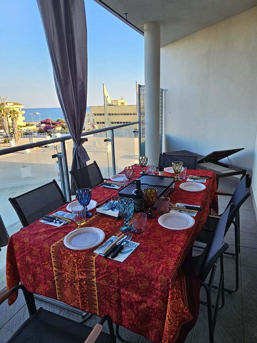 La tavola apparecchiata sul terrazzo di Shogun Porto, con il mare sullo sfondo